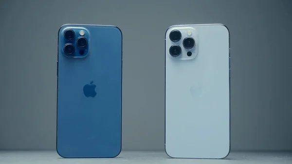RUSIA, MOSCÚ - 27 de septiembre de 2021: Colorear iPhones. Acción. Comparación de dos iPhones de Apple. Dos teléfonos idénticos con diferentes tonos de colores. Nuevo diseño de iPhone 13 pro —  Fotos de Stock