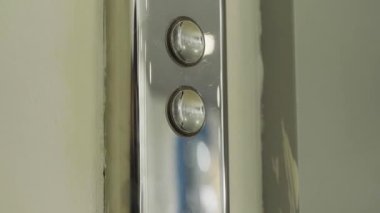 Asansör düğmesi ve bej bir duvar. HDR. Halka açık bir asansörün metal düğmelerini kapatın. Alışveriş merkezinde..