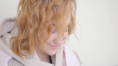 Kadın oturuyor ve telefona bakıyor. Başla. Telefonda oturan güzel bir kadının yakın çekimi. Güneşli bir günde telefonda gülümseyen bir kadın.