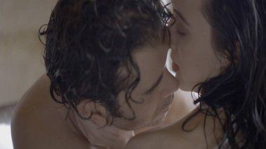 Güzel, tutkulu bir çift birbirine yakındır. Başla. Tutkulu erkek ve kadın kucaklaşır ve okşarlar. Islak saçlara aşık bir çift ve tutkuyla sarılıyorlar.