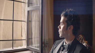 Eski iç mekanın arka planında takım elbiseli yakışıklı bir adam. Başla. Siyah takım elbiseli çekici bir adam eski ortamda poz veriyor. Siyah takım elbiseli, papyonlu seksi adam.