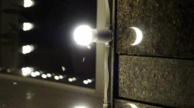 Kelebekler yanan ampule üşüşürler. HDR. Kapatın güveleri ve sinekleri Lambanın yanında uçun Gece bir bina duvarında.