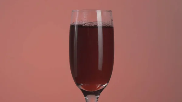 Il primo piano di succo di ciliegia o melograno è versato in un bicchiere. Azione. Riempire un bicchiere trasparente con un delizioso succo, concetto di dieta vitaminica. — Foto Stock