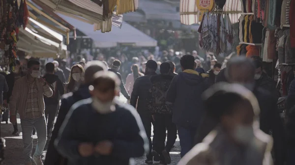 街上的人都戴口罩。行动。在街头市场上，一群头戴口罩的人沿着不同的商品走着. — 图库照片
