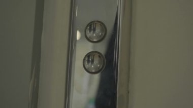 Mans asansör aşağı tuşuna elle basıyor. HDR. Asansörü almak için gümüş metal düğmeye basarak erkek parmağını kapat..