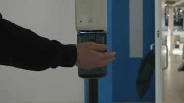 İş merkezinin içinde otomatik alkol dezenfektanı ile ellerini yıkamayı unutma. HDR. Koronavirüs salgınının önlenmesi.