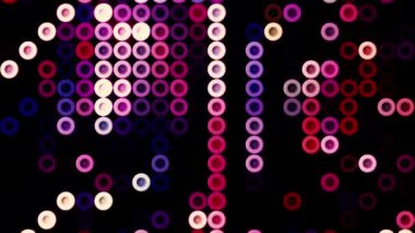 Soyut yuvarlak renkli düğmeler siyah bir zemin üzerinde hareket ediyor, pürüzsüz bir döngü. Hareket. Mor tonlarda çalışan halka siluetleri.