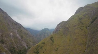 Şiddetli bulutlu arka planda pitoresk bir geçitin havadan görünüşü. Başla. Yeşil yaz ormanlarıyla kaplı yüksek dağlar..