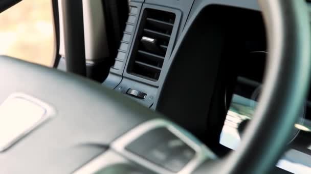 Close-up van het instrumentenpaneel voor personenauto 's met een stuurwiel en veel knoppen. Plaats delict. Interieur van een modern comfortabel voertuig. — Stockvideo