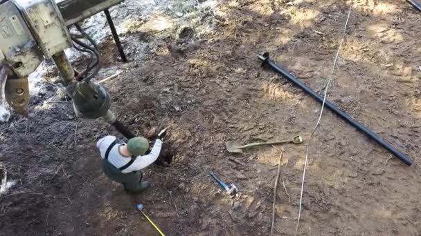 Fluxo de trabalho. Criativa. Uma visão drone de um homem de uniforme trabalhando na lama com equipamento especial. — Vídeo de Stock