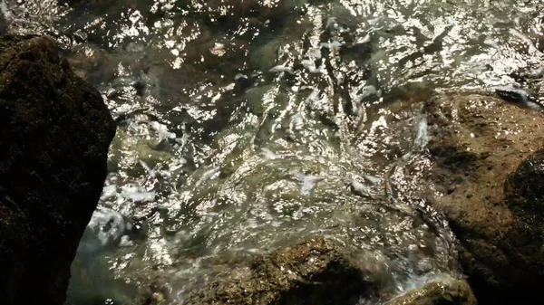 La riva del fiume. Creativo. Acqua limpida del fiume che batte contro le rocce sulla riva — Foto Stock