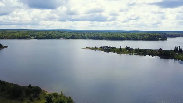 Widok z drona. Klip. ogromne czyste jezioro w tle jest duży zielony las i spokojne niebo. — Zdjęcie stockowe