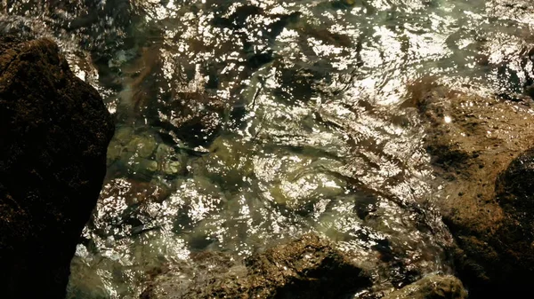 La riva del fiume. Creativo. Acqua limpida del fiume che batte contro le rocce sulla riva — Foto Stock
