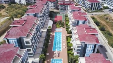 Bir İHA 'dan tatil köyünün görüntüsü. Şarjör. Arka planda geniş evleri ve dinlenme alanları olan berrak mavi deniz dağları görülebilir..