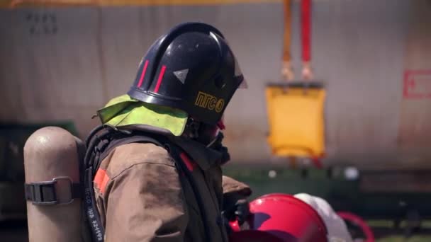 Робочий процес. Кліп. Пожежник в уніформі і шоломі використовує піну  . — стокове відео