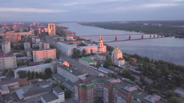 Het uitzicht vanaf de drone. Een knip. Een prachtige avond stad in Rusland met een brug een rivier en huizen tegen een mistige lucht — Stockvideo