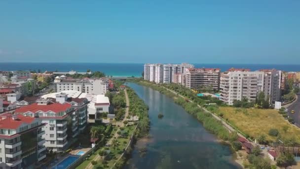 Het uitzicht vanaf de drone. Een knip. Uitzicht op de blauwe heldere oceaan in de buurt van het resort met zwembad en huizen . — Stockvideo