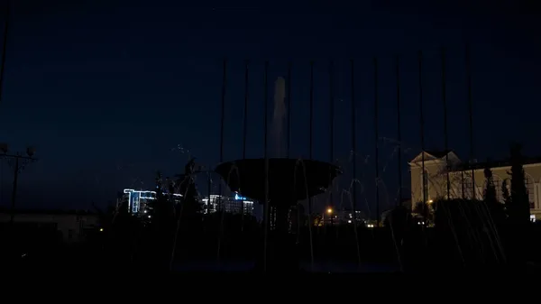 Paysage nocturne de la ville avec le beau bâtiment administratif et une fontaine sur fond de ciel bleu foncé. L'action. Concept d'architecture. — Photo