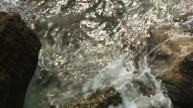 Nehir kıyısında. Yaratıcı. Temiz nehir suyu kıyıdaki kayalara vuruyor.