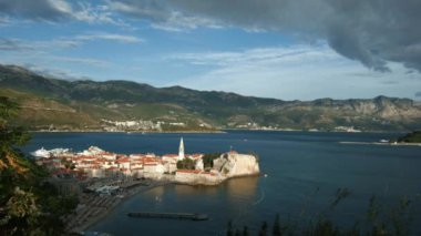 İnsansız hava aracından güzel bir manzara. Yaratıcı. Önünde büyük yeşil dağlar, beyaz evler ve yakınlarda bir yol ve gri bulutlu bir gökyüzü olan deniz..