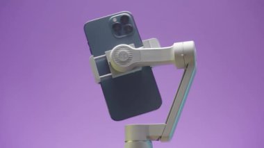 Kanada - Ottawa, 11.25.2021: yeni modern cihaz içeren akıllı telefon esnek dengeleyicisine yakın çekim. Başla. Telefon tripodun içinde dönüyor..