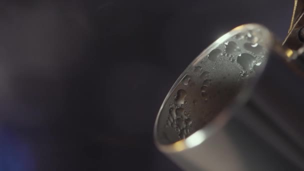 Extreme close up of steel kettle spout with drops of water on its surface. Action. Steam coming from the kettle spout on blurred background. — Stock Video