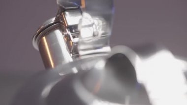 Bulanık gri duvar arka planında gümüş bir su ısıtıcısının kapalı kısa çıkıntısını çevirmeye yakın. Başla. Dönen yeni çaydanlık.