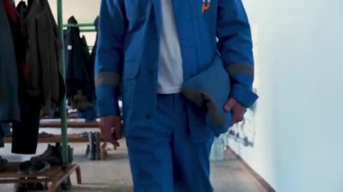 İş kıyafetleri. Şarjör. Fabrika işi için mavi takım elbise ve arkadaki çeşitli iş ceketleri.