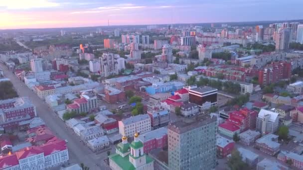 Novosibirsk 'in Kirovsky bölgesinde kuş bakışı. Şarjör. Güzel ve zarif bir gün batımı, kocaman evler ve bir yol. — Stok video