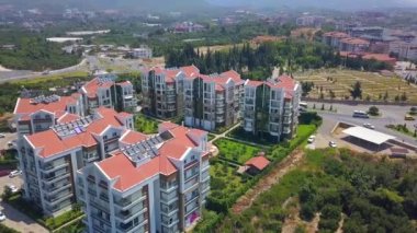 Kuş bakışı görüş. Şarjör. Çevresindeki yeşil parkların ve arka plandaki dağların yanında yüzme havuzu olan bir yazlık yer..