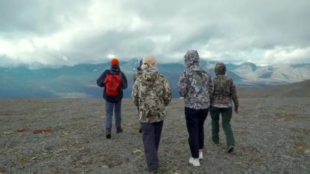人々は巨大な山を見ている。クリップ。悪天候の旅行者のグループと霧の大きな山を見て. — ストック動画