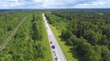 Helikopterden harika bir yeşil yol. Şarjör. Etrafında arabalar ve kocaman yeşil bir yaz ormanı olan uzun asfalt bir yol..
