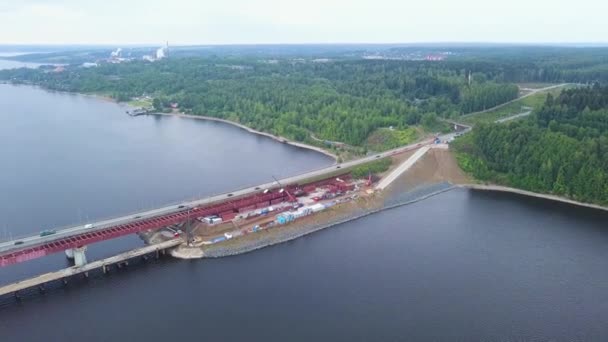 Utsikten från drönaren. Klipp. En enorm södra bro där bilar kör omgiven av vatten av en skog och molnfria moln är något synliga. — Stockvideo