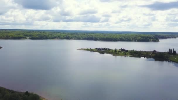 A vista do drone. Clipe. um enorme lago claro no fundo é uma grande floresta verde e um céu calmo. — Vídeo de Stock