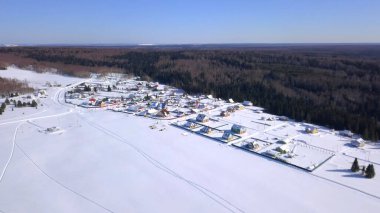 Kuş bakışı görüş. Şarjör. Köyün yakınındaki kış ormanı, orman, tarlalar ve mavi gökyüzü.