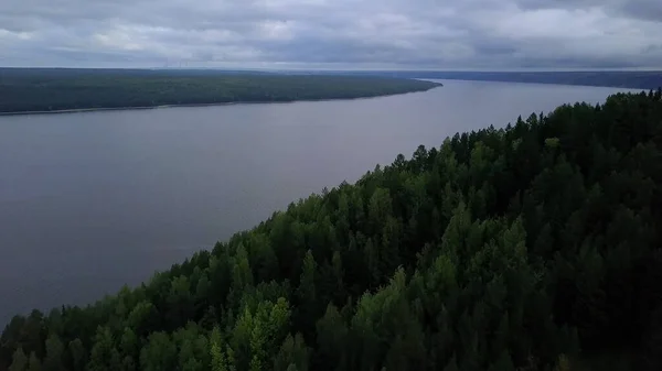 Der Blick aus der Drohne. Clip. Ein großer Teich, über dem ein Wald und ein grauer Himmel liegen — Stockfoto