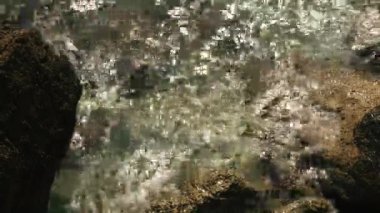 Nehir kıyısında. Yaratıcı. Temiz nehir suyu kıyıdaki kayalara vuruyor.