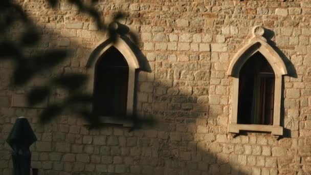 The view from the drone. Creative. A beautiful brick architectural building with green vegetation nearby and open dark windows — Stock Video