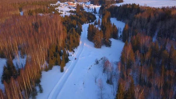 Вид з дрона. Кліп. Величезний сніжний зимовий ліс зі снігопадами, на якому ходять електричні машини з людиною . — стокове фото