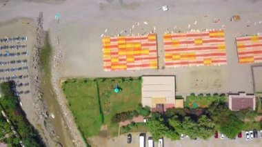 Kuş bakışı görüş. Şarjör. Sahilin yanında büyük bir okyanus. İnsanların yüzdüğü, kumla rahatladığı ve atlamak için küçük bir köprü..