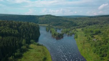 İnsansız hava aracının görüntüsü. Şarjör. Büyük bir yaz göleti ve etrafında bir orman ve büyük yeşil ağaçlar ve tepemizde mavi bir gökyüzü..