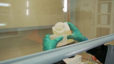 Laboratuvarda çalış. Şarjör. Sıvıyı döküp kontrol eden bir kimyagerin işi.