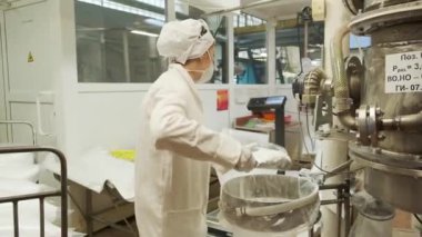 İşlem süreci. Klip. Özel paltolu işçilerin çalıştığı bir motor fabrikası.