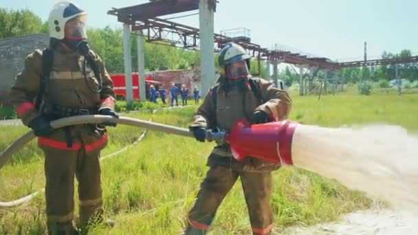 Feuerwehrleute setzen ihre Ausrüstung ein. Clip. Retter löschen mit Wasser oder überprüfen den Betrieb des Inventars . — Stockvideo