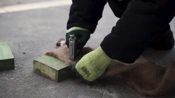Tumbando el suelo. Clip. Un hombre hace una fibra especial para el aislamiento de pisos en casas con una grapadora. — Vídeos de Stock
