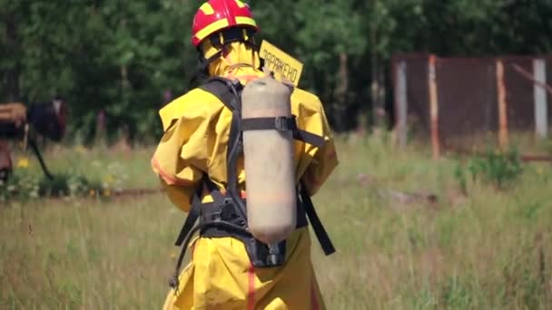 Una señal de peligro. Clip. Personas que realizan trabajo en una zona peligrosa que va a una máscara de gas en el fondo de una señal de advertencia de peligro — Vídeo de stock