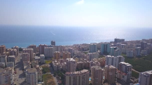 Фото с вертолета. Клип. Красивый пейзаж, где можно увидеть синее море, солнце, небо и высотные здания. — стоковое видео