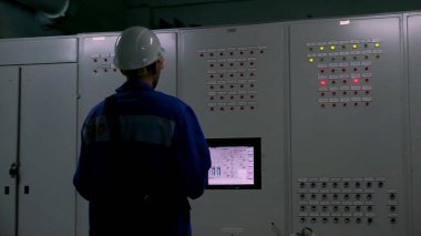 İşgücü. Şarjör. Fabrikada çalışan bir adam üretim için bir şeyler yapar..