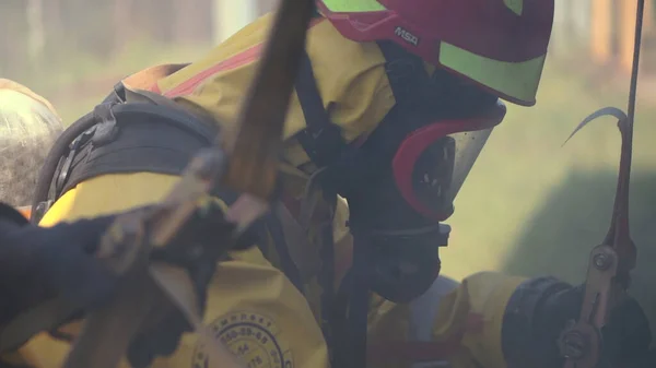 Memeriksa masker gas. Jepit. Seorang pria bertopeng gas menghirup udara beracun selama proses kerja dengan bantuan rekannya. — Stok Foto