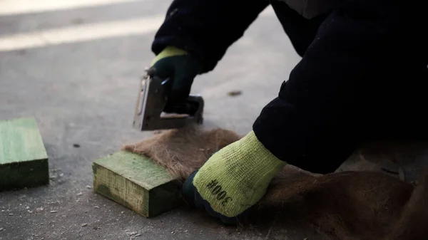 Položit podlahu. Klip. Člověk vyrobí speciální vlákno pro izolaci podlah v domech se sešívačkou. — Stock fotografie
